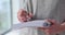 Woman stands holding pen and writing in diary closeup