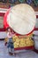 A woman stands beside a large drum