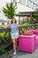 A woman stands next to a pink bench with flowers on the Kazan embankment