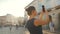 Woman stands on an old street and takes a photo or video on a smartphone at sunset