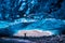 Woman stands in the opening of an ice cave in the Vatnajokull glacier in southeast Iceland