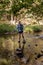 Woman Stands On Rocks While Crossing Creek