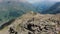 Woman stands on stone and enjoys view of Elbrus mountains