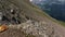 Woman stands on stone and enjoys view of Elbrus mountains