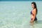 woman stands in a swimsuit at a clear sea