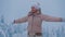 Woman stands on top of a mountain, enjoying fantastic winter northern landscape