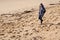 Woman stands walk sand sea beach in winter and enjoys the sun