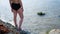 Woman stands and wets feet in water. Concept. Beautiful women`s feet cool in sea during hot summer day. Woman resting on