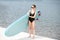 Woman with standup paddleboard on the beach