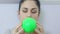 Woman start blowing green balloon