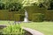 Woman statue and a pond at a yew topiary garden in Tiverton, Devon, England