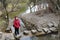 Woman stepping on the stone block across the river