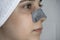 A woman sticks a cleansing strip on her nose. Black dots on the nose. Girl without makeup in the bathroom. Skin care, problem skin