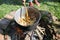 Woman stirring in a cast iron cauldron where a goulash stew is b