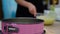 Woman stirring dough with a pink baking pan