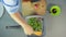 Woman stirring green beans roasting in a skillet with a wooden spatula