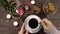 Woman stirring hot coffee with a spoon.Table with candles, rose and gold ring in a gift box.