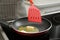 Woman stirring melted butter in frying pan on stove