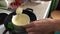 Woman stirring white chocolate on a plate. The chocolate is melted in a water bath to make a dessert. Nearby are other ingredients