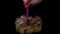 Woman stirs a cold drink with a cocktail straw on a black background