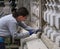 Woman stone conservator working on ancient stone carved balustrade.