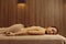 Woman with stones on back lying on massage table