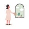 The woman stood, watering the flowers and cactus on the window and looking out the window to see the sky