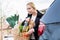 Woman storing basket with groceries into trunk after shopping