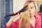 Woman straightening her long blond hair