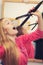 Woman straightening her long blond hair