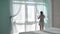 Woman straightens tulle on beautiful panoramic window, home cleaning, cozy house, step 1