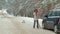 Woman with a straw car on the road in winter