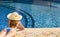 Woman in straw hat near the pool