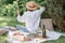 Woman in straw hat on picnic holding a glass of wine from behind. Summer time adventures