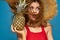 Woman in a straw hat with pineapple in her hands wavy hair exotic fruits you summer blue background vacation