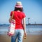Woman in straw hat with sunglasses and bag on west breakwater in Swinoujscie by navigational mark Windmill Stawa Mlyny. Vacation