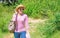 Woman in straw hat walking in nature background. Woman going picnic in nature. Girl hiking or going to picnic in forest