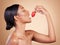 Woman, strawberry and eating for natural skincare, beauty and nutrition cosmetics against a studio background. Female