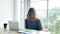 Woman streching arm raised sitting incorrect position home office desk. Back side of young asian woman tired from work body stress