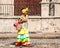 Woman on the street in Cuba in colorful dress selling flowers