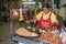 woman at the street sells fresh noodles, eggs, soja beans with salad at a movable food stall in Bangkok by night