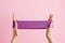 Woman stretch fitness band. Violet rubber for home exercises. Indoor and outdoor workout. Sport and healthy active lifestyle