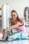 Woman stretches her legs and warms up before having a dumbbell workout in the gym with water bottle ready next to her