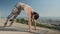 Woman stretching body outdoors. Trainer doing yoga at viewpoint of Barcelona