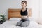 Woman stretching and cool down after workout in her apartment room.