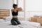 Woman stretching and cool down after workout in her apartment room.