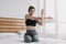 Woman stretching and cool down after workout in her apartment room.