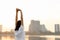 Woman is stretching her arms before workout outdoors in the city. Healthy young woman warming up outdoors in the morning