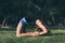 Woman stretching in Kapotasana yoga pose under the morning sun