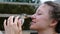 Woman strokes and holds a small chicken in her hands and is moved by a bird in close-up